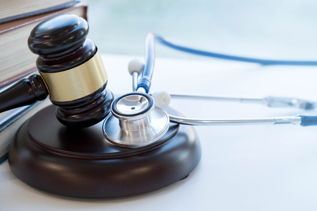 Direito da Saúde para medicamentos para pacientes oncológicos, representado por martelo de justiça e estetoscópio